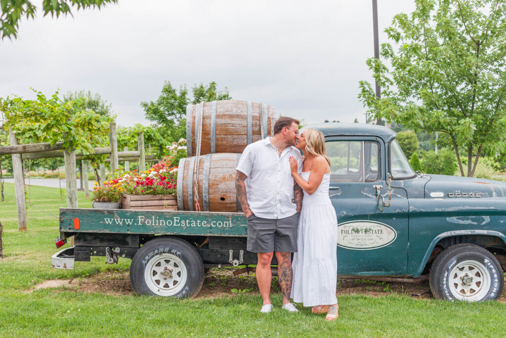 Chelsea and Julian near the rustic pickup truck at Folino Estate Winery during their engagement session.