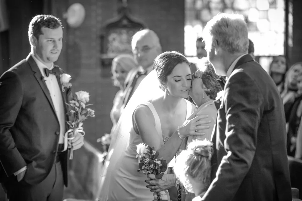 Bride kissing mother during emotional Philadelphia church wedding ceremony