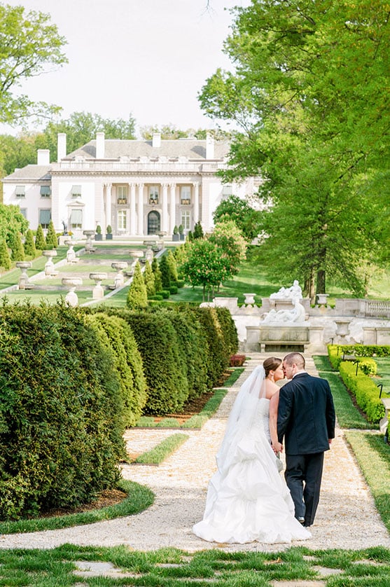 Bride and groom walking through the gardens at Nemours Estate on their wedding day