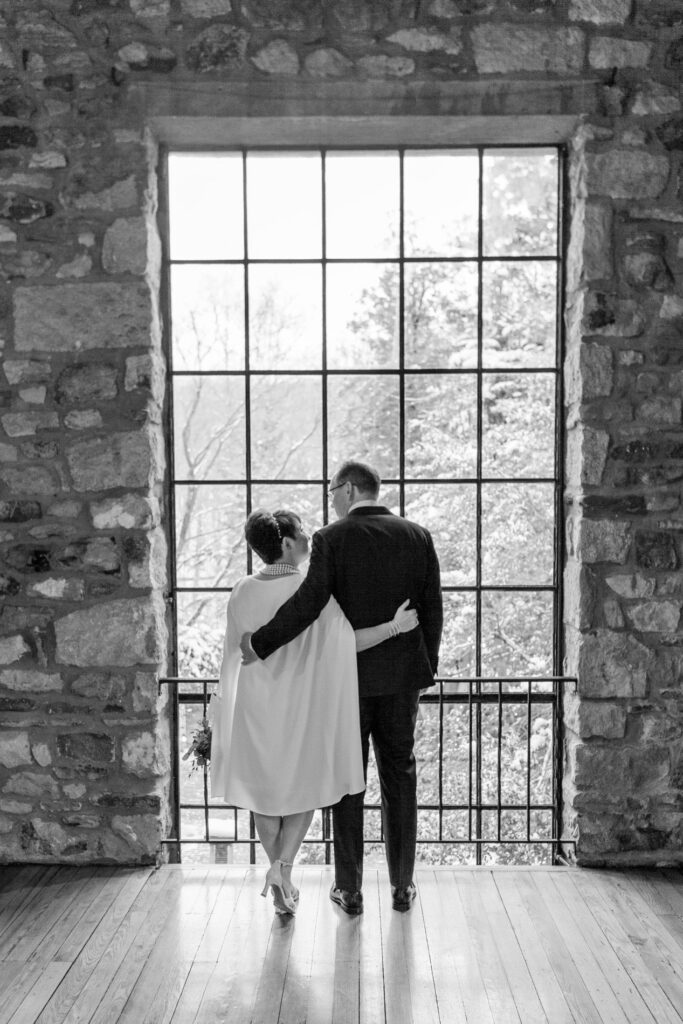 Natural light pours through the tall windows of the Old Barn ceremony space at Holly Hedge Estate, creating dramatic portraits for couples on their wedding day.