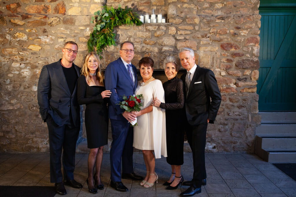 Family gathers for a portrait during the reception at Holly Hedge Estate in New Hope, Pennsylvania, surrounded by the venue’s historic stone walls and warm evening light.