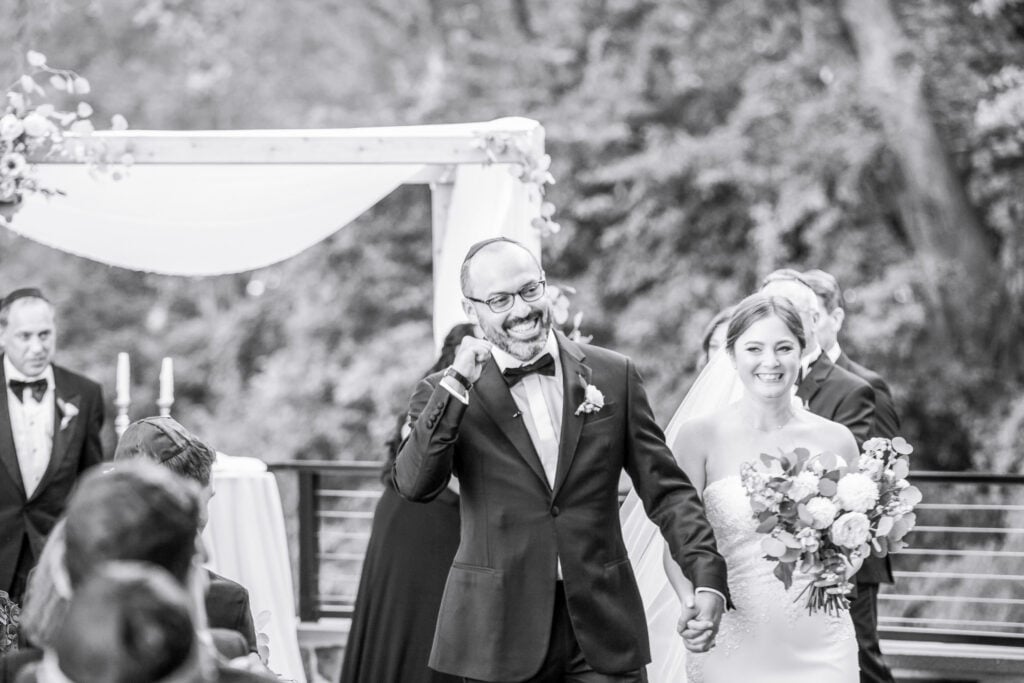 Couple celebrating after their outdoor wedding ceremony at The River House at Odette’s in New Hope, Pennsylvania