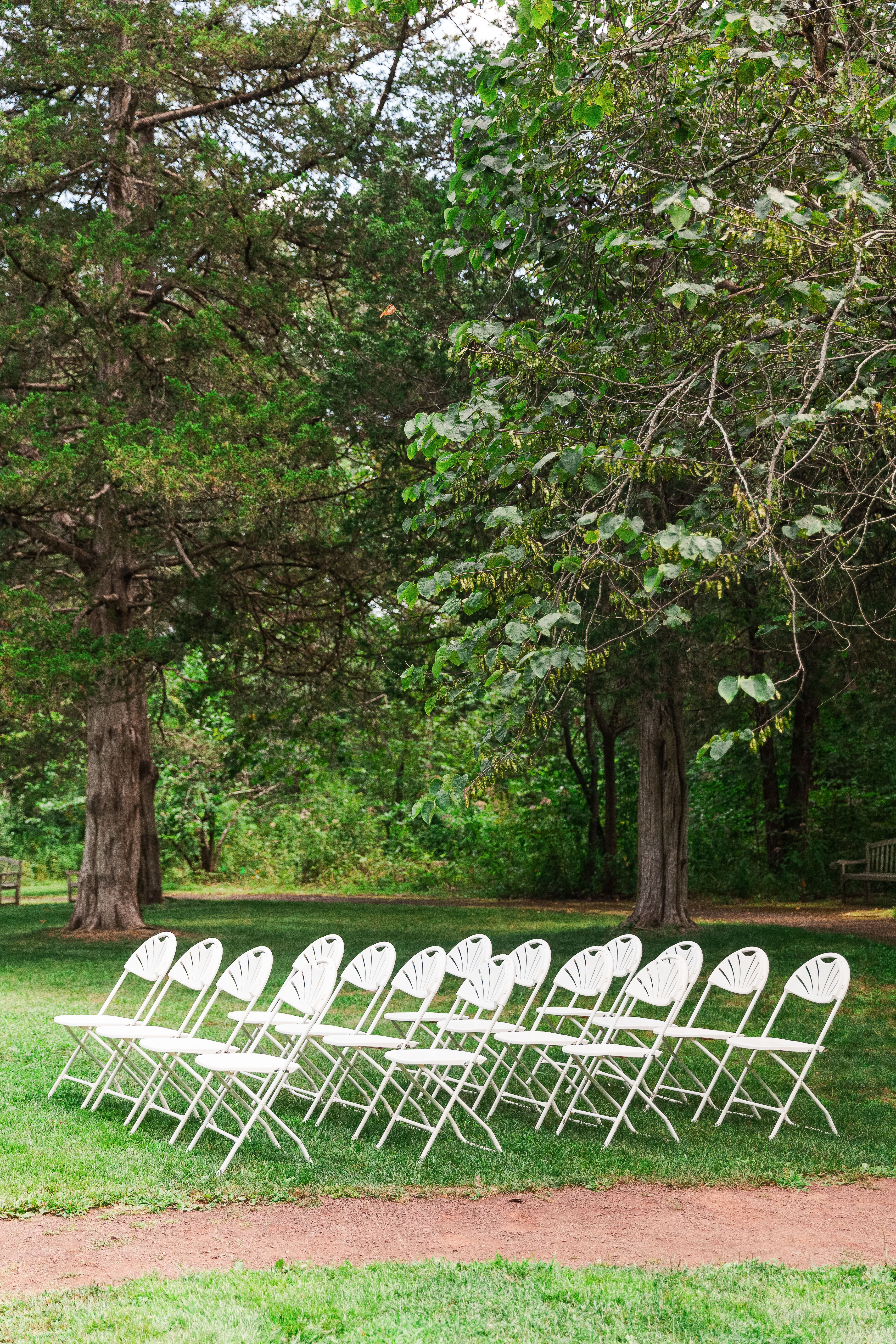 Ceremony chairs wait beneath the trees at the Pond at Bowman’s Hill Wildflower Preserve.