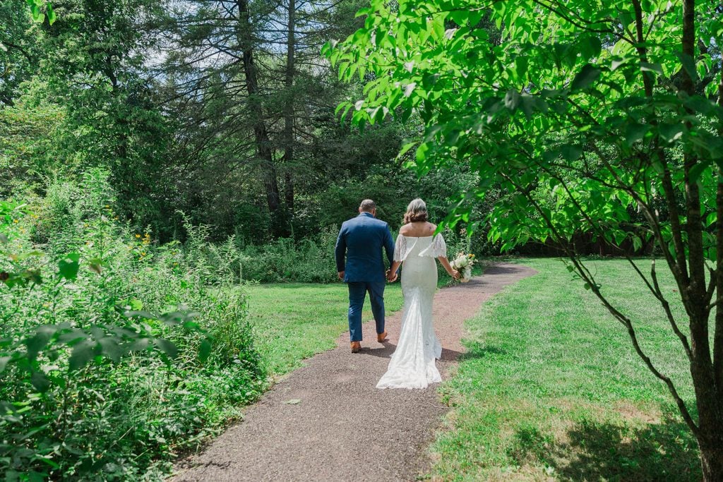 A newly married couple walks together along a shaded garden path at Bowman’s Hill Wildflower Preserve.